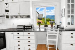 a white kitchen with a counter and a window at Charming Casa Hauge BB Sunset Room in Sandane +47 photos