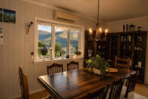a dining room with a wooden table and a window at Charming Casa Hauge BB Sunset Room in Sandane