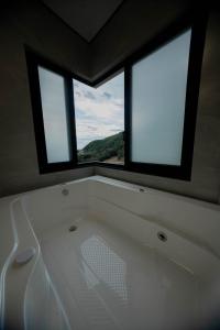 eine Badewanne in einem Zimmer mit zwei Fenstern in der Unterkunft Hotel Cantuccio in Arroio Trinta + 43 Fotos