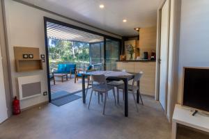 a kitchen and dining room with a table and chairs at Delya, chalet confort, climatisation, piscine in Agde