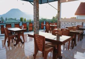 a restaurant with tables and chairs and a balcony at Homestay Reyna in Ende Airport