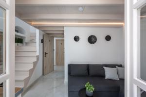 a living room with a gray couch and stairs at Symi Duo in Symi