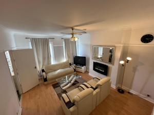 a living room with a couch and a tv at Cozy Spacious Flat in South Norwood