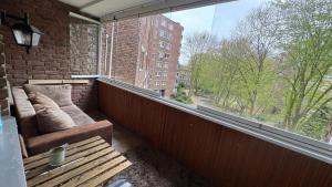 a balcony with a couch and a large window at Spacious 3-room apartment with balcony in Mönchengladbach
