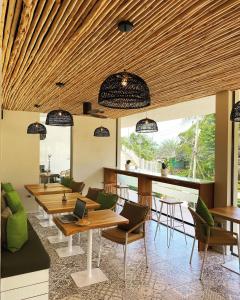 a restaurant with wooden tables and chairs and a bar at Bay Villas Koh Phangan in Salad Beach