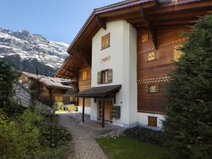 a large wooden building with mountains in the background at Apartment Chalet Nagano by Interhome in Grindelwald
