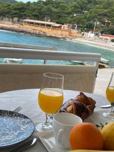 a table with a glass of orange juice and a plate of food at Studio apartment Milna, Hvar Buratovic in Hvar +19 photos