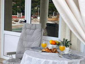 a table with a plate of food and orange juice at Studio apartment Milna, Hvar Buratovic in Hvar