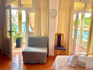 a bedroom with a bed and a chair and a clock at Studio apartment Milna, Hvar Buratovic in Hvar