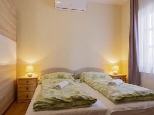 a bedroom with two beds and two lamps and a window at Holiday Home Tamas by Interhome in Balatonőszöd