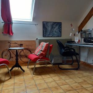 a room with chairs and a table and a bike at L'ABRI in May-sur-Orne