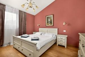 a bedroom with a white bed and red walls at Villa Ana by Rent Istria in Vilanija