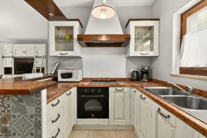 a kitchen with white cabinets and a sink at Villa Ana by Rent Istria in Vilanija +28 photos
