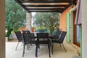 a black dining table and chairs on a patio at Villa Ana by Rent Istria in Vilanija