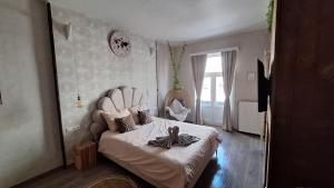 a bedroom with a white bed with a large headboard at "Chez Ba'Nus" in Blankenberge