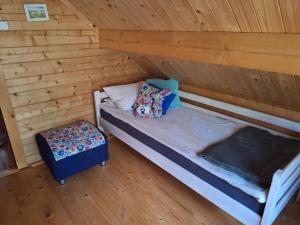a room with a bed in a wooden cabin at Szumi szumi LAS in Joniec