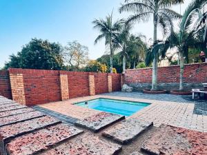 a backyard with a brick wall and a swimming pool at Fisherman's 6-Bedroom Family Home in St Lucia