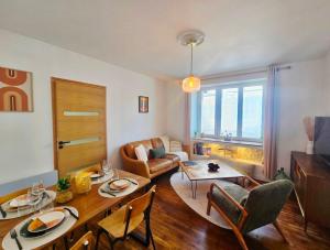 a living room with a table and a couch at Au Petit Crecy in Crécy-la-Chapelle