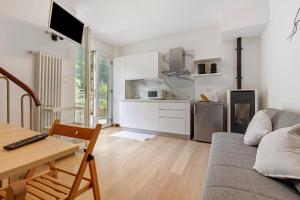 a living room with a couch and a table and a kitchen at Villa Ulrica in Nago-Torbole