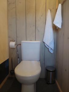 a bathroom with a toilet and towels hanging on the wall at casa la luna glamping in Alhaurín el Grande +8 photos