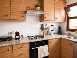 a kitchen with wooden cabinets and a stove top oven at Blue House Calafell in Calafell