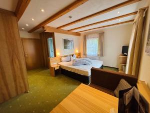 a hotel room with two beds and a couch at Pension Bergheim in Tannheim