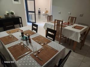 a dining room with two tables and chairs with glasses at Pado B & B in Gqeberha