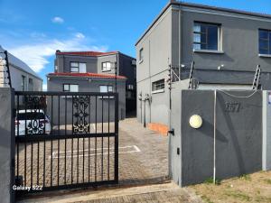 a gate in front of a building with a house at Pado B & B in Gqeberha