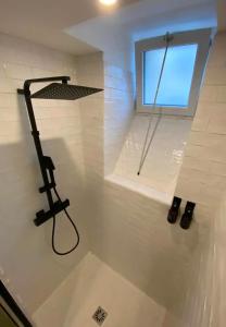 a shower in a bathroom with a window at Au Petit Crecy in Crécy-la-Chapelle +15 photos