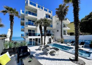 a large building with a swimming pool and palm trees at AGATA BEACH Boutique -Adult Only in Ahtopol