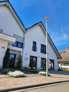 a white building with a street light in front of it at Pension Yvonne - SUPERIOR - am Europa-Park in Rust