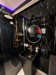 a black bathroom with a sink and a mirror at Love room Coconut Secret in Le Gosier