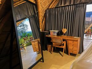 a room with a desk and a table and a window at Circle House Bamboo Sidemen in Silebeng