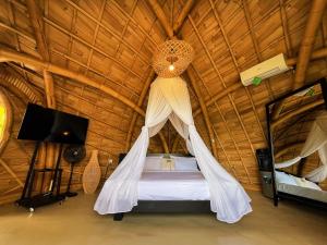 a bedroom with a bed with a mosquito net at Circle House Bamboo Sidemen in Silebeng