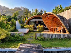 a garden with a tub and a house at Circle House Bamboo Sidemen in Silebeng