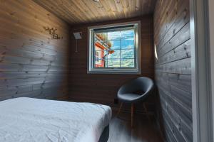 a small bedroom with a bed and a window at Manndalen Sjøbuer in Samuelsberg +78 photos