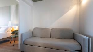 a living room with a chair and a bed at Kyriad - Royan Plage in Royan