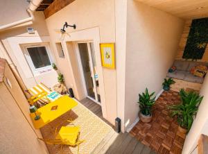 a balcony of a house with a yellow table and chairs at Au Petit Crecy in Crécy-la-Chapelle