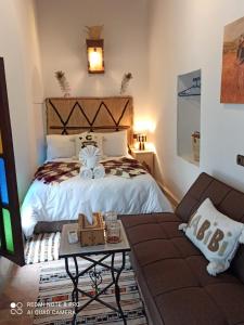 a bedroom with a bed and a couch at Riad la Fíbula de Nora in Fez