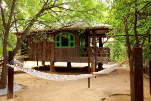a tree house with a hammock in front of it at Ananya Eco Resort in Surūrnagar