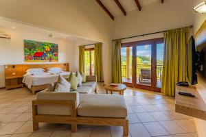 a hotel room with two beds and a couch at Valmer Resort and Spa in Baie Lazare Mahé