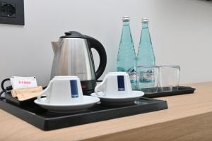 a black tray with two cups and bottles on a counter at Veranda Hotel by Mirage in Ksamil
