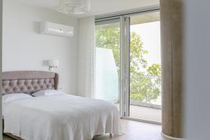 a bedroom with a bed and a large window at Green Cape Botanico in Batumi +70 photos