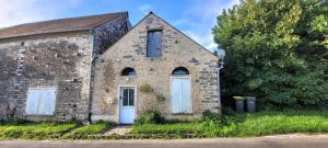 an old stone building with a blue door at Gîte de Préaux in Tousson