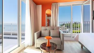 a bedroom with a couch and a bed and a window at Kyriad - Royan Plage in Royan