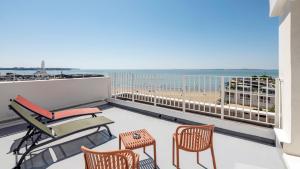 a balcony with chairs and a view of the beach at Kyriad - Royan Plage in Royan
