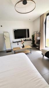 a bedroom with a bed and a flat screen tv at KL Studios in Al Khobar