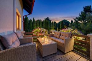 a patio with two couches and a table on a deck at JD Apartamenty - Klimatyzacja, basen, parking i wifi w cenie in Mysłakowice +26 photos