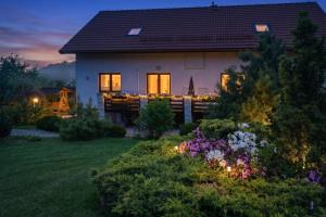 a house with lights in the yard at night at JD Apartamenty - Klimatyzacja, basen, parking i wifi w cenie in Mysłakowice