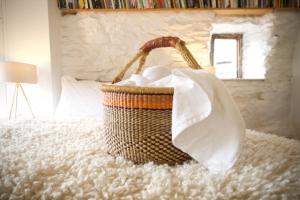 a basket of towels sitting on a bed at Wester Auchraw Croft B&B in Lochearnhead